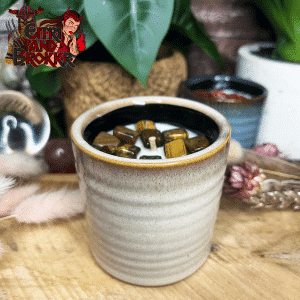Bougie parfumée avec pierres dans un pot en céramique couleur crème